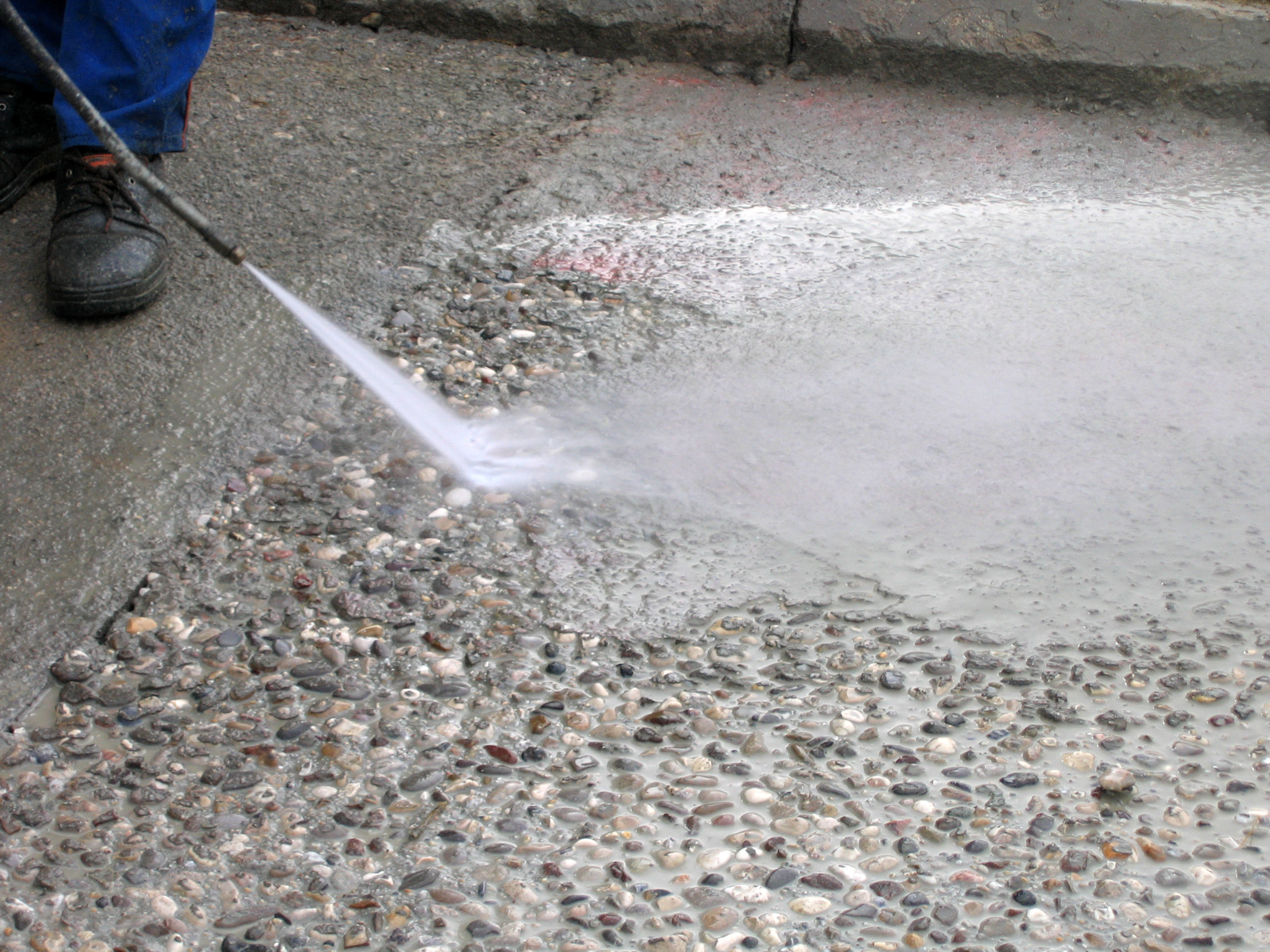 Spraying to expose aggregate on concrete surface using surface retarder