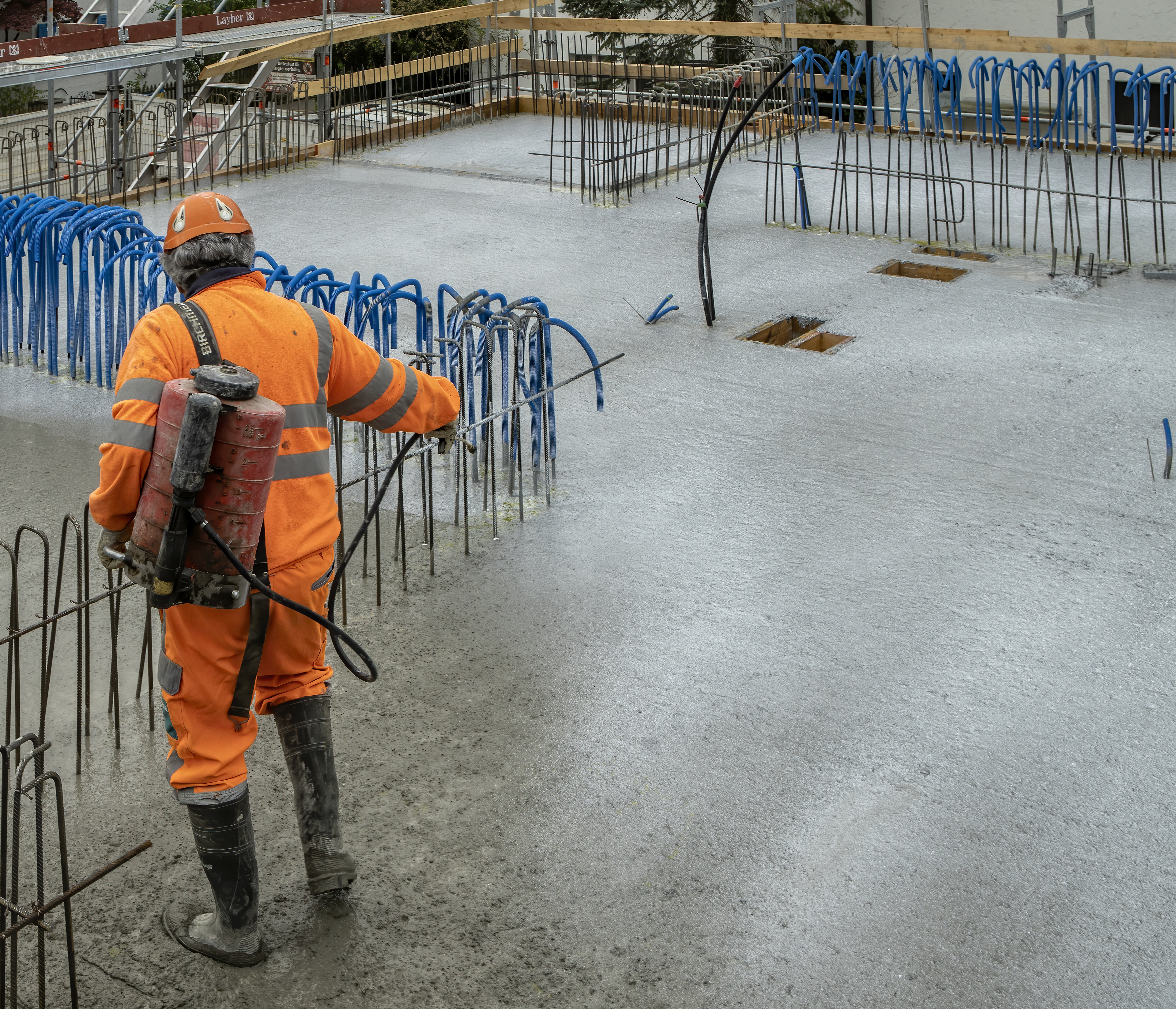 Man applying Sika® Antisol® curing compound on concrete on construction site with reinforcement